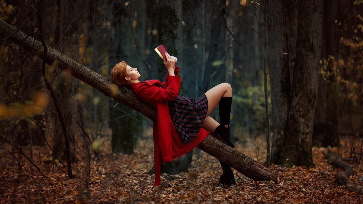 Girl Reading Book Lying On Back Outdoors