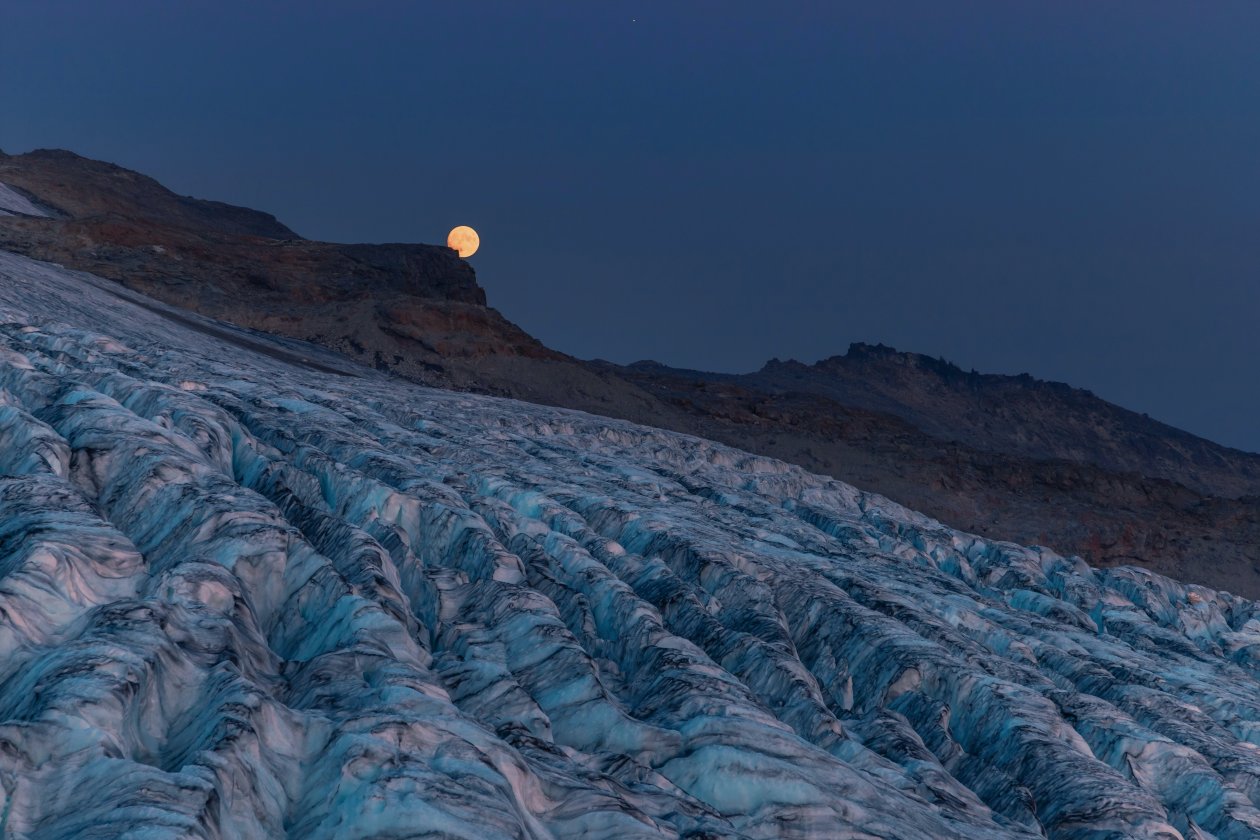 Moon Rising Over A Glacier With Mountains