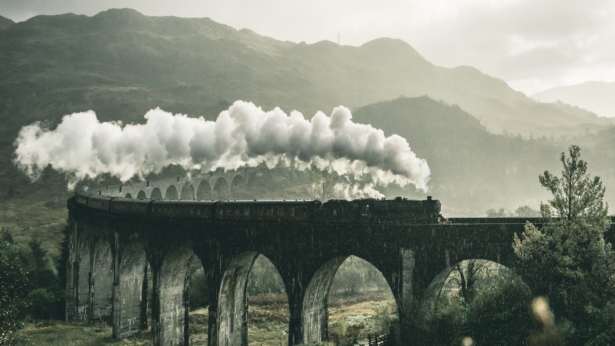 Black Train On Railway Bridge Under Heavy Clouds