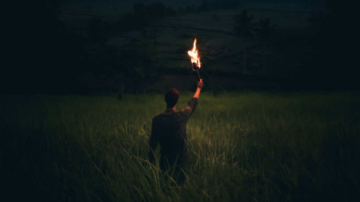 Man Through Dark With Wooden Torch