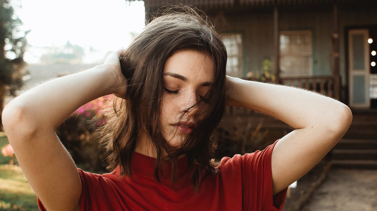 Woman Raising Hand Holding Her Hairs