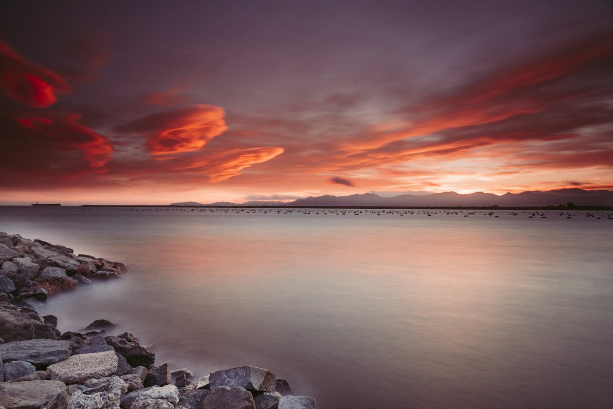 Rocks Near Body Of Water During Sunset