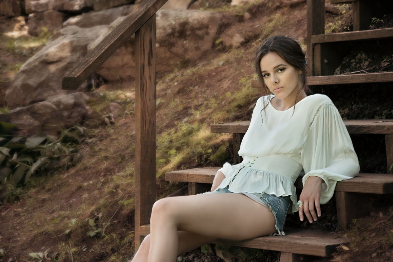 Beautiful Girl Sitting On Brown Wooden Stairs