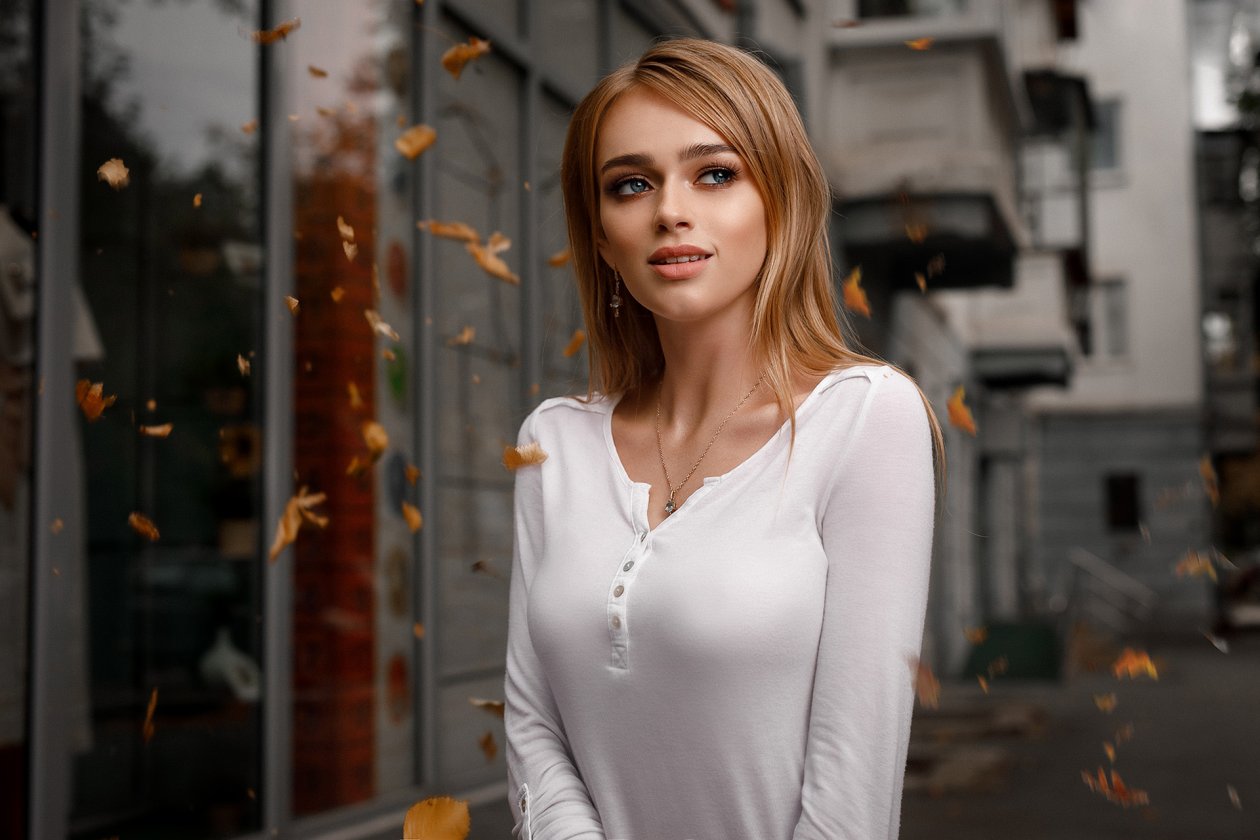 Beautiful Blonde Girl With Falling Leaves In The Autumn