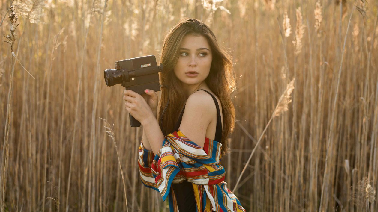Brunette Girl In Field With Camera