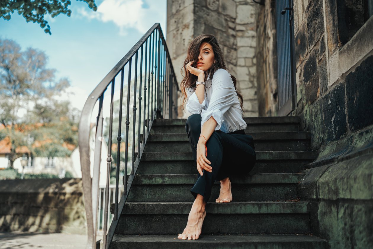 Girl Sitting On Stairs Hands On Chin 5k