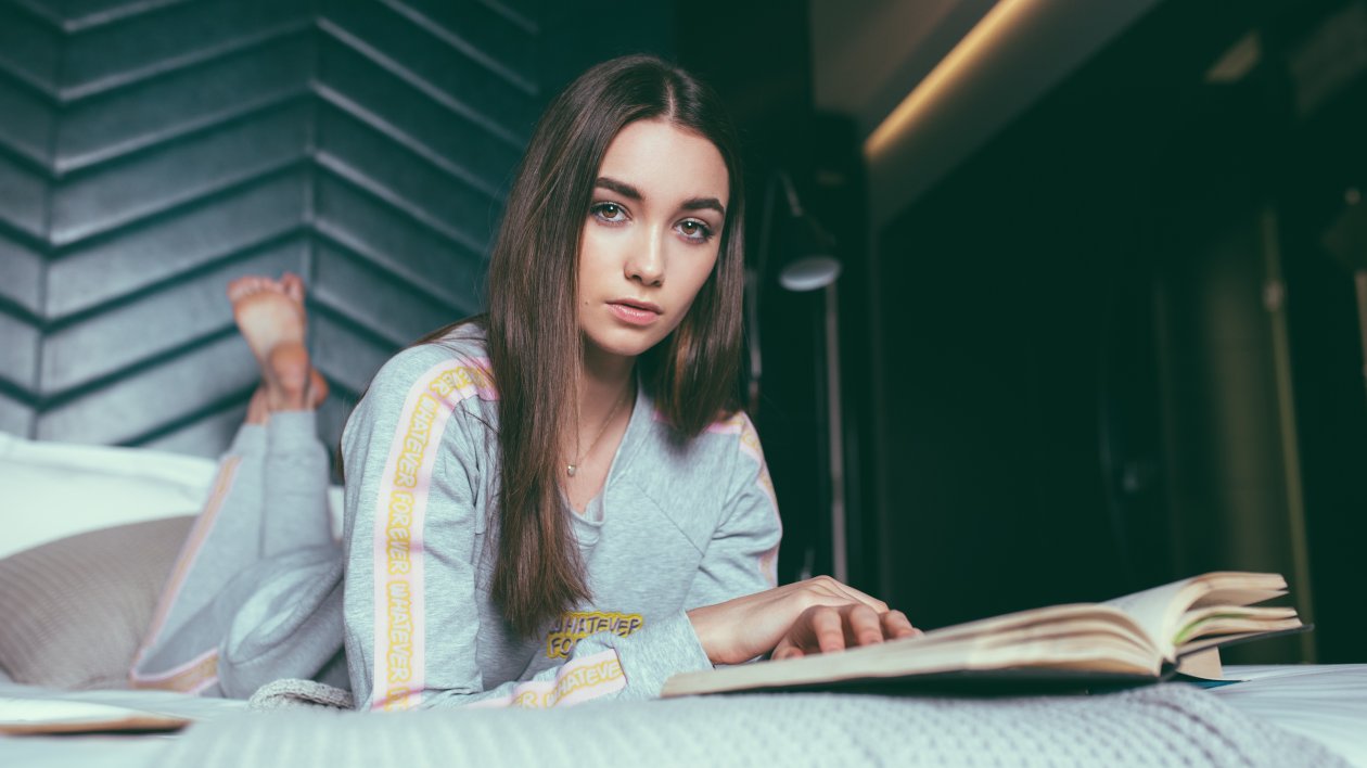 Women Brown Eyes Book In Front Looking At Viewer