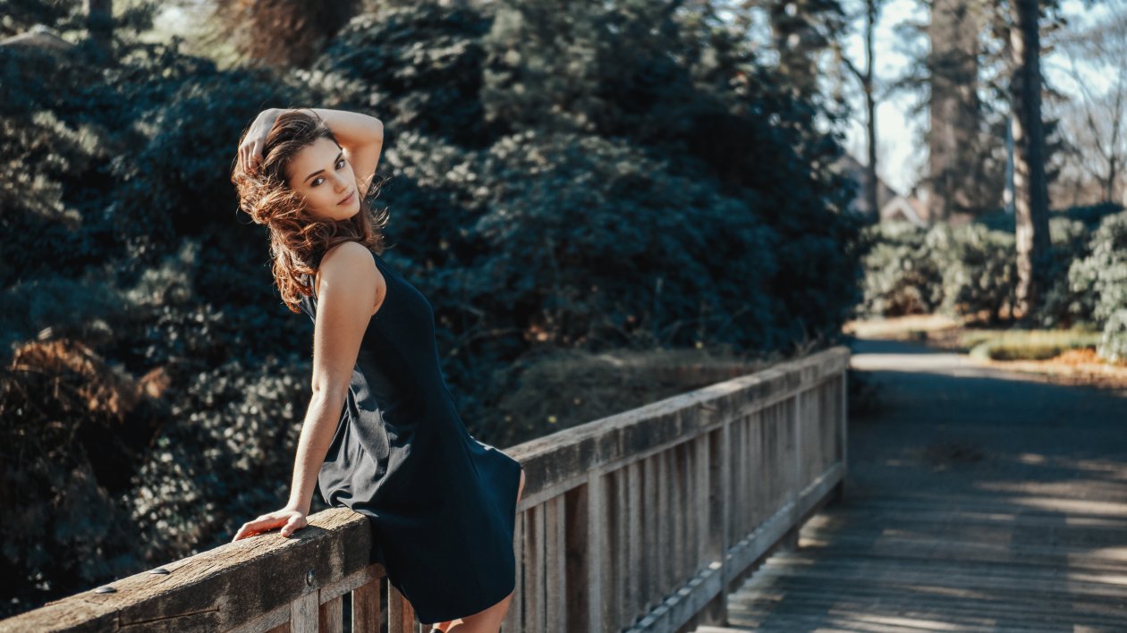 Girl Sitting On Wooden Bridge Looking Back