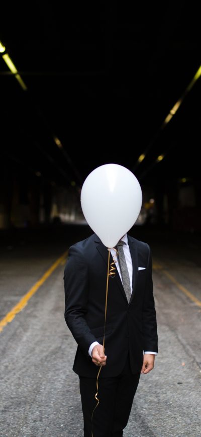 Fond d'écran iPhone Young Man In Suit Holding Balloons In Front Of Face