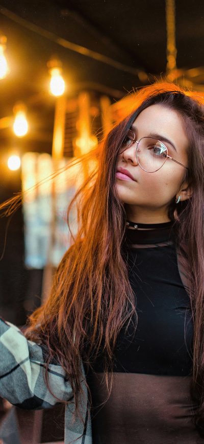 Fond d'écran iPhone Girl Glasses Playing With Hair Restaurant Lights 4k