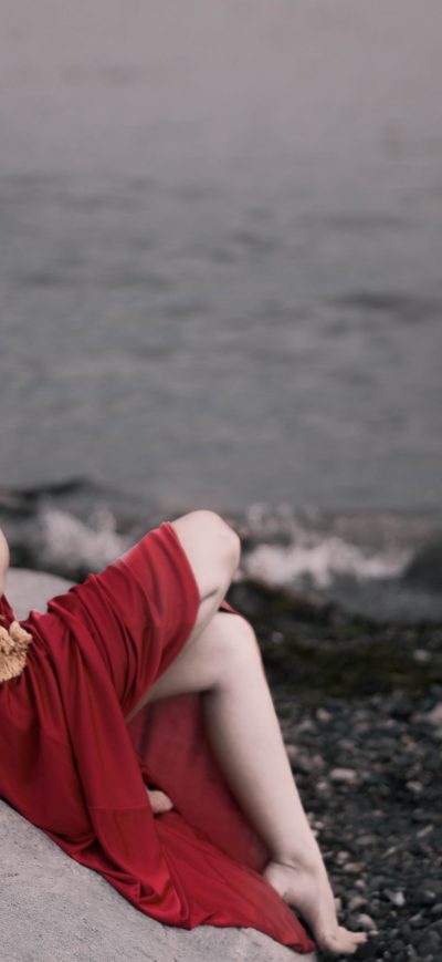 Fond d'écran iPhone Girl In Red Dress Sitting On Rocks Beach 8k