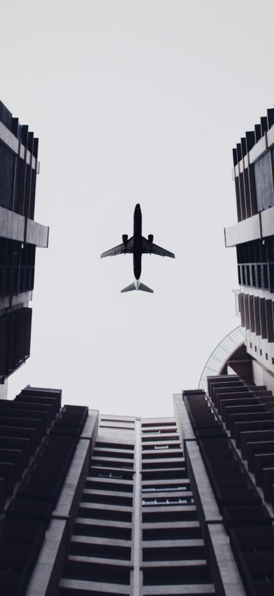 Fond d'écran iPhone Airplane Flying Above The Buildings 5k