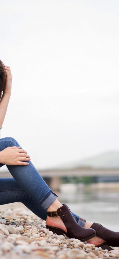 Fond d'écran iPhone Girl Sitting Rocks Hands In Hair Looking 4k