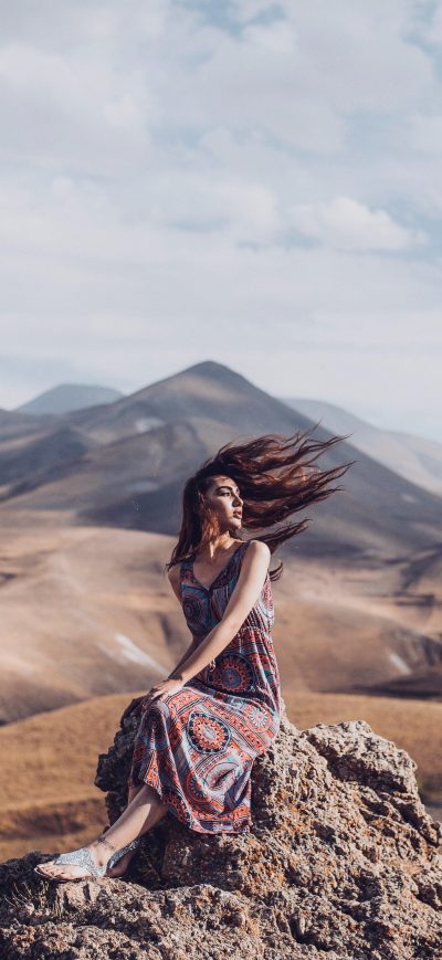 Fond d'écran iPhone Girl Sitting On Rock Hairs In Air