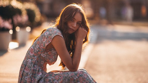 Woman In White And Brown Floral Dress Sitting On Gray Concrete Road During Daytime 5k