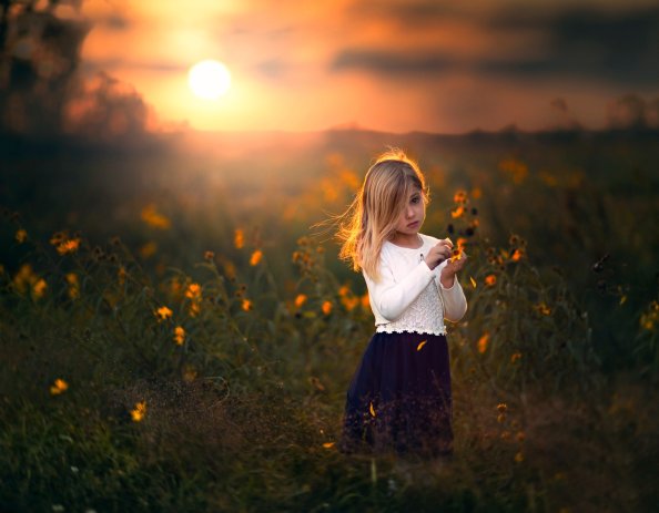 Cute Child Girl With Flowers Outdoors