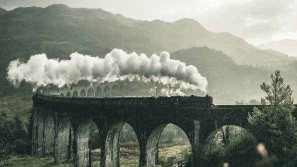 Black Train On Railway Bridge Under Heavy Clouds