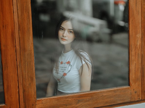 Beautiful Girl Looking Through Window