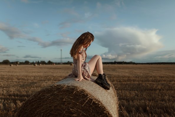 Girl Sitting On Straw Roll