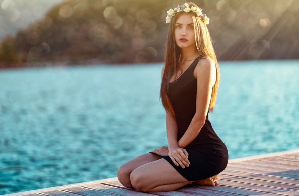 Brunette Girl In Black Dress Sitting At Pier Side