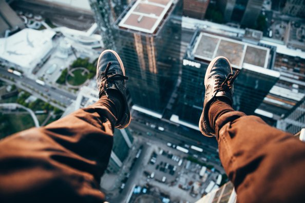 Man Sitting On Top Of A Rooftop
