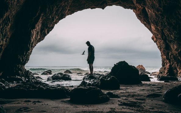 Man Standing In Front Of Cave 8k
