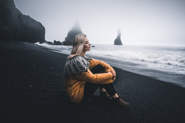Girl In Sweater Sitting With Eyes Closed Sitting At Beach