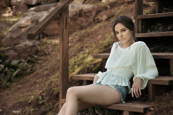 Beautiful Girl Sitting On Brown Wooden Stairs