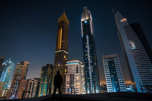 Man Standing Front Of Tall Buildings