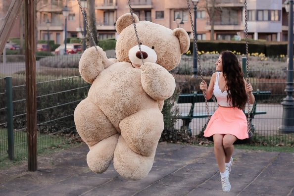 Girl With Big Teddy Bear On Swing