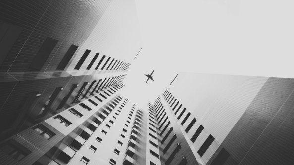 Airplane Flying Above Skyscrapers