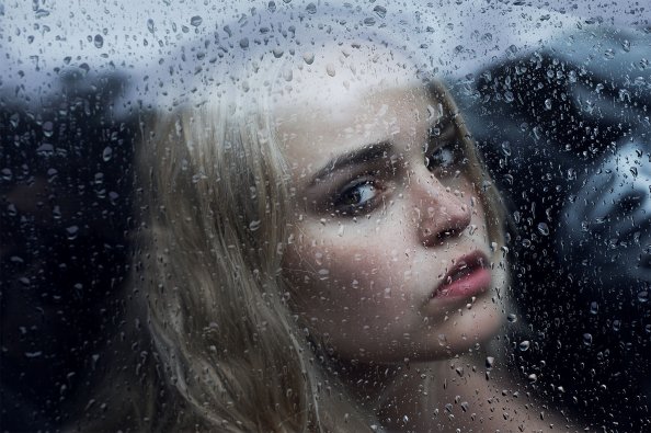 Girl Behind The Glass With Water Drops