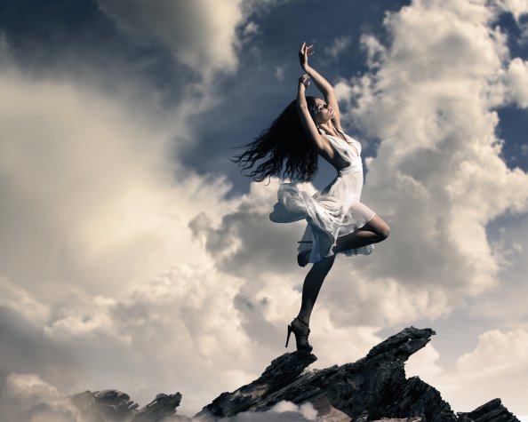 Brunette Girl Dancing On Mountain Top Clouds